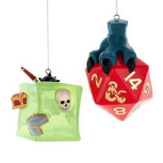 Two colorful hanging toy bags: a green cube-shaped backpack with a skull window and a tiny chest attached, and a red die-shaped block with a blue claw on top.