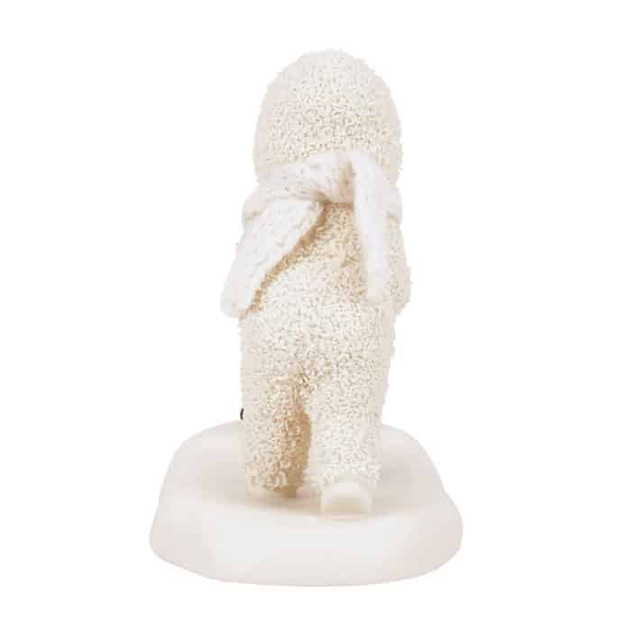 Back View of a Small White Bunny Sculpture Covered in White Sugar Sprinkles Standing on a White Pedestal