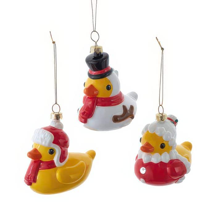 Three Holiday Rubber Duck Ornaments Hanging by Strings Each in Festive Outfits santa Hatsscarves Against a White Background with Central Duck Wearing a Black Top Hat