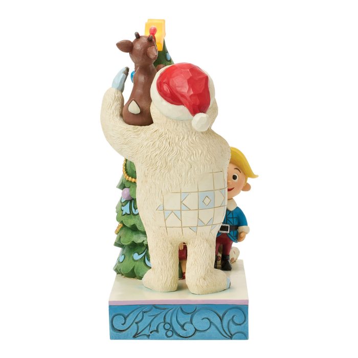 Decorative Holiday Statue a Beige Llama Wearing a Red Santa Hat with a Christmas Tree and a Child Peeking from Behind on a Blue Base